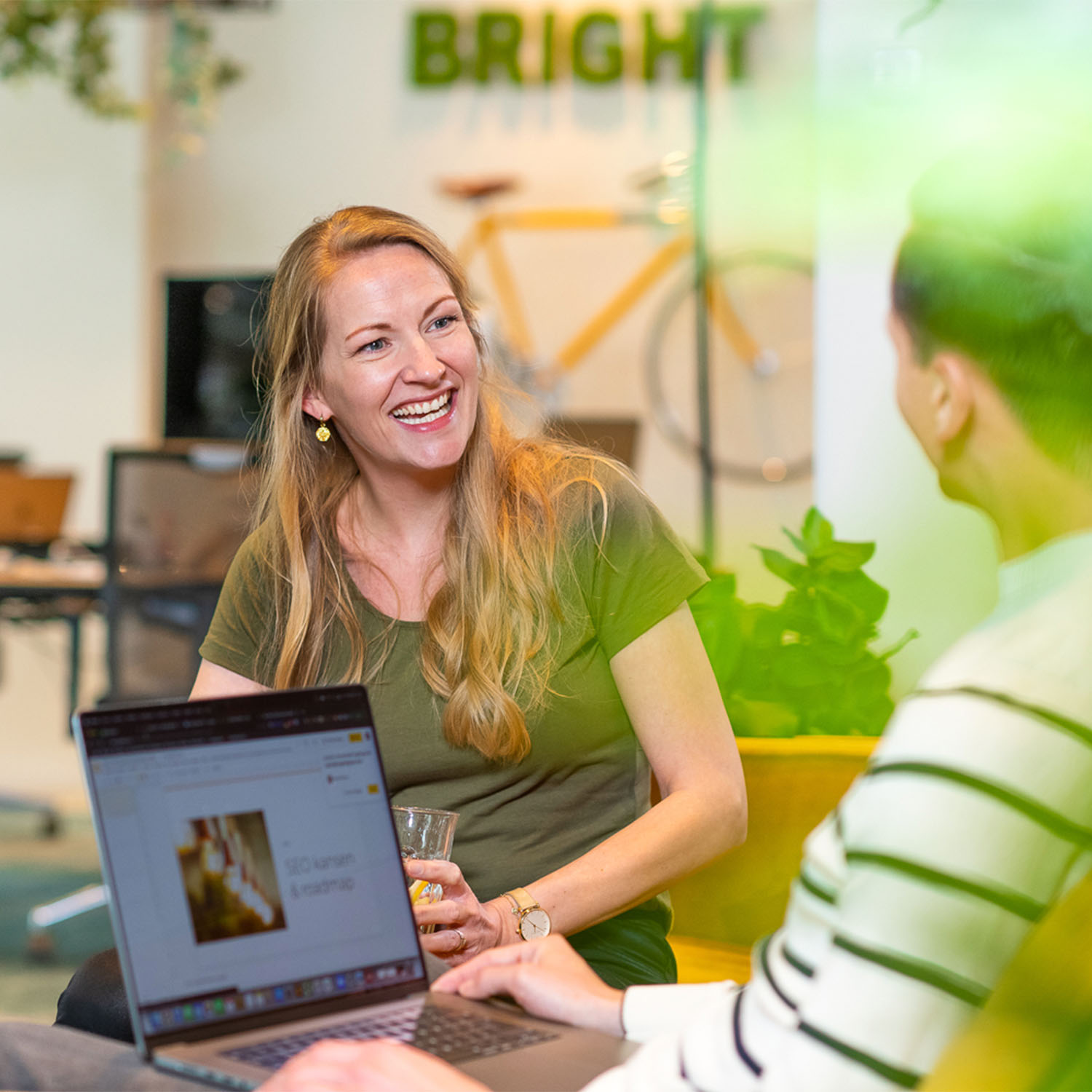 Collega's van Bright digital agency werken samen op een gele bank